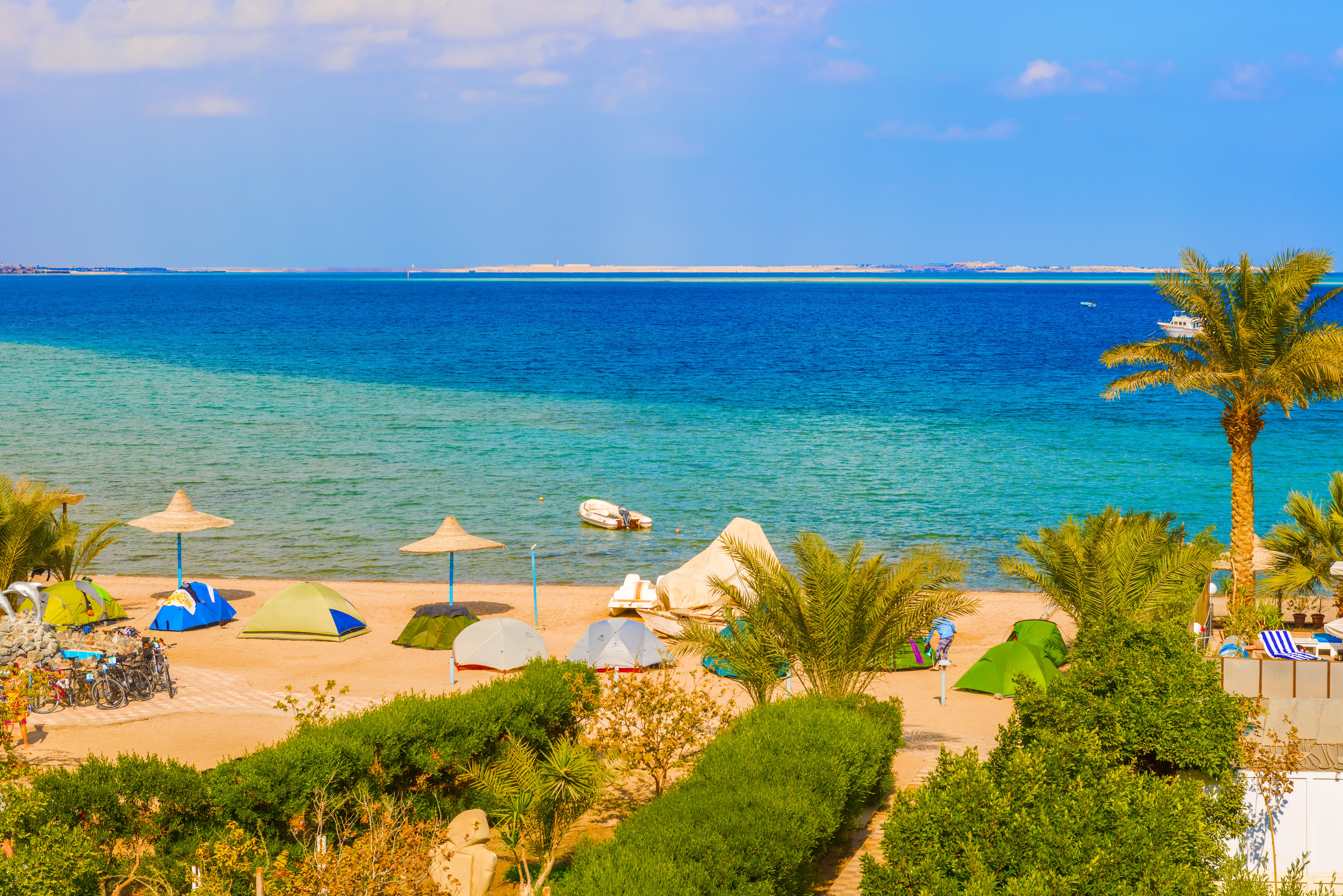 Golden sand beach, palm trees and beautiful blue sea of Safaga, Egypt.