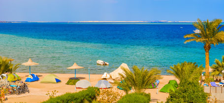 Golden sand beach, palm trees and beautiful blue sea of Safaga, Egypt.