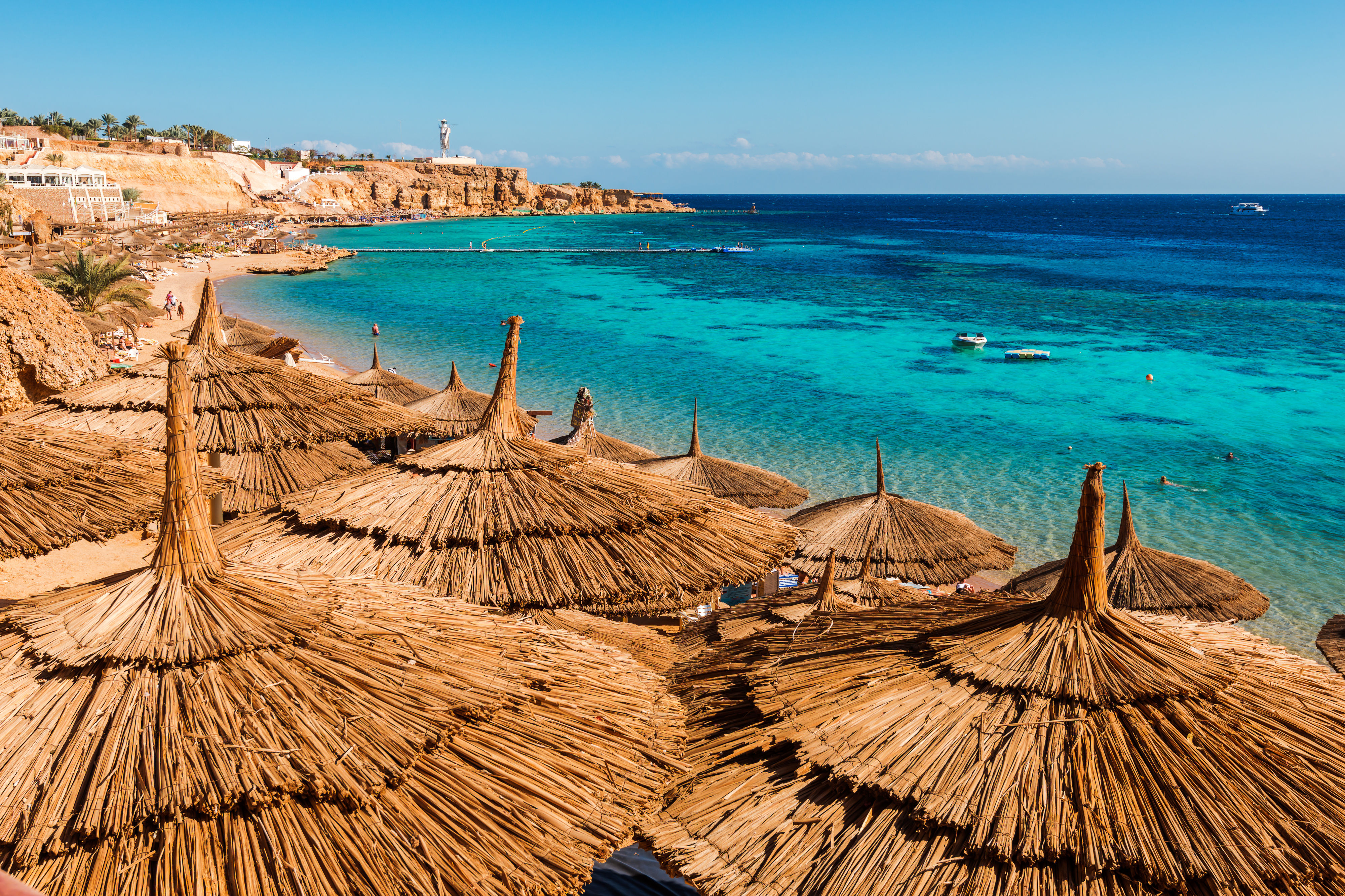 Straw umbrellas along the red sea coast line and shallow reefs of Sinai, Egypt