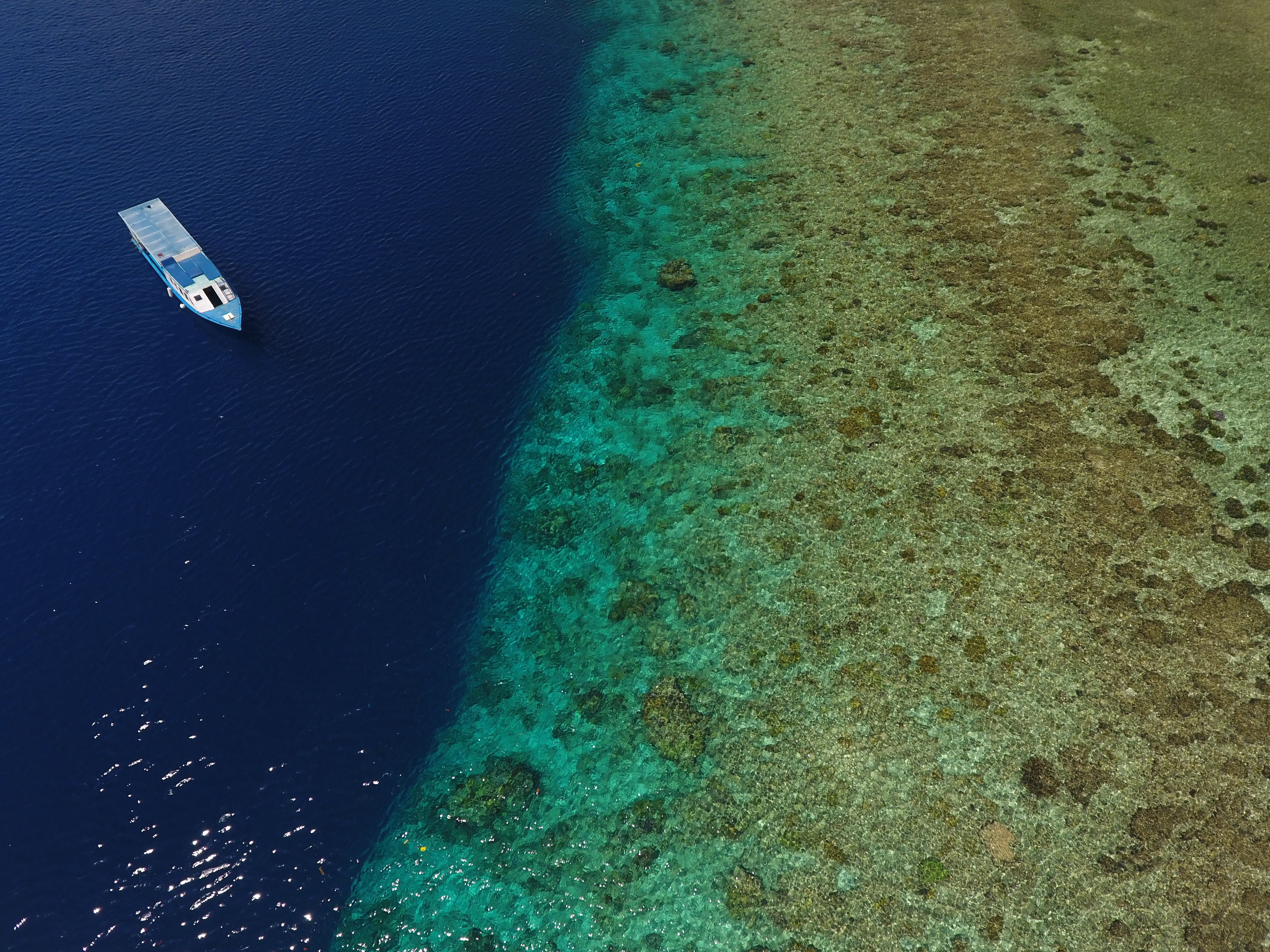 Scuba diving boat next to coral reef on tropical sea in Manado Indonesia.