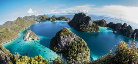 Aerial view of Indonesian archipelago, Raja Ampat jungle covered Islands in tropical seas.