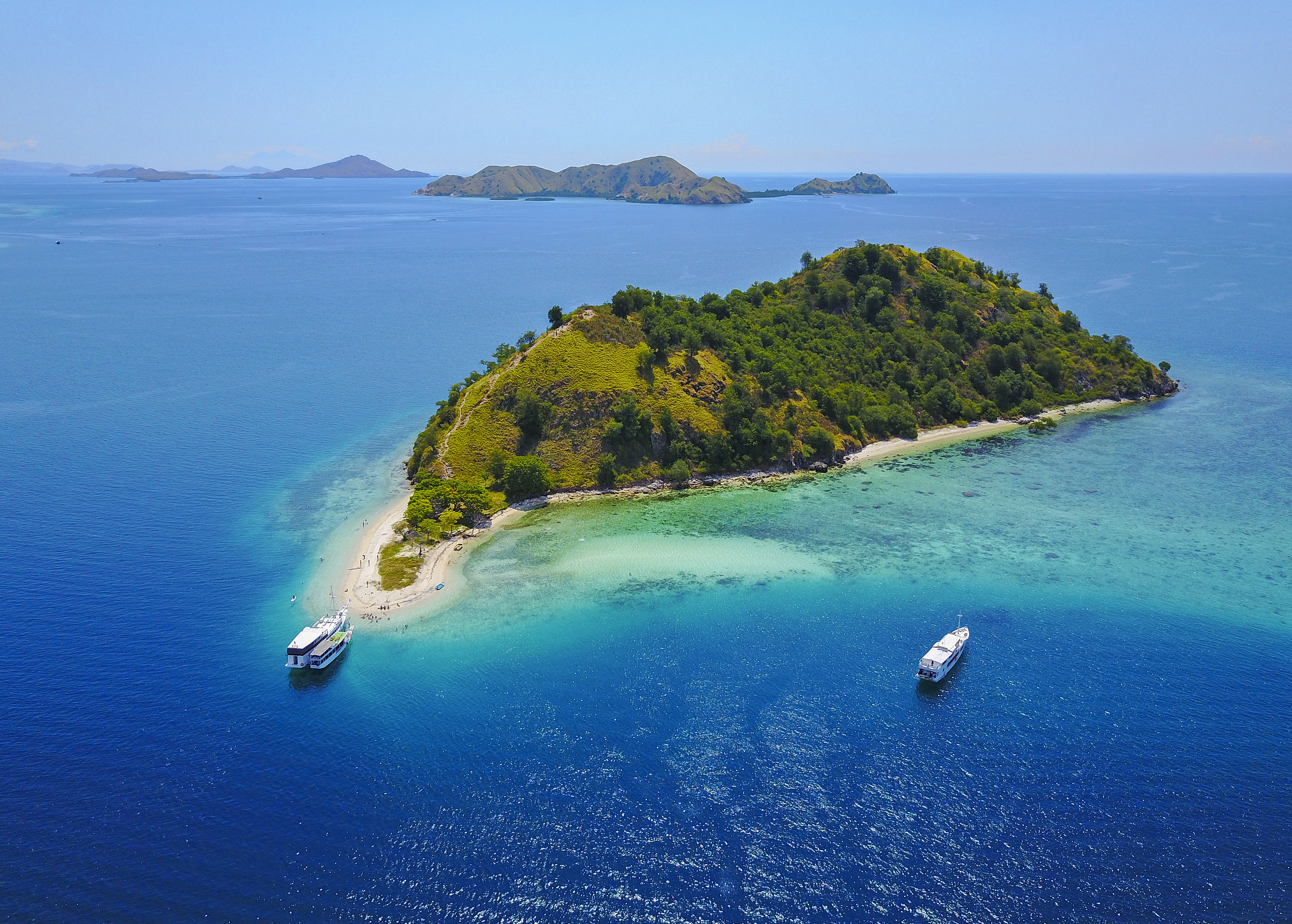 Aerial view of Flores with tour boat, turquoise and blue sea in Indonesia.