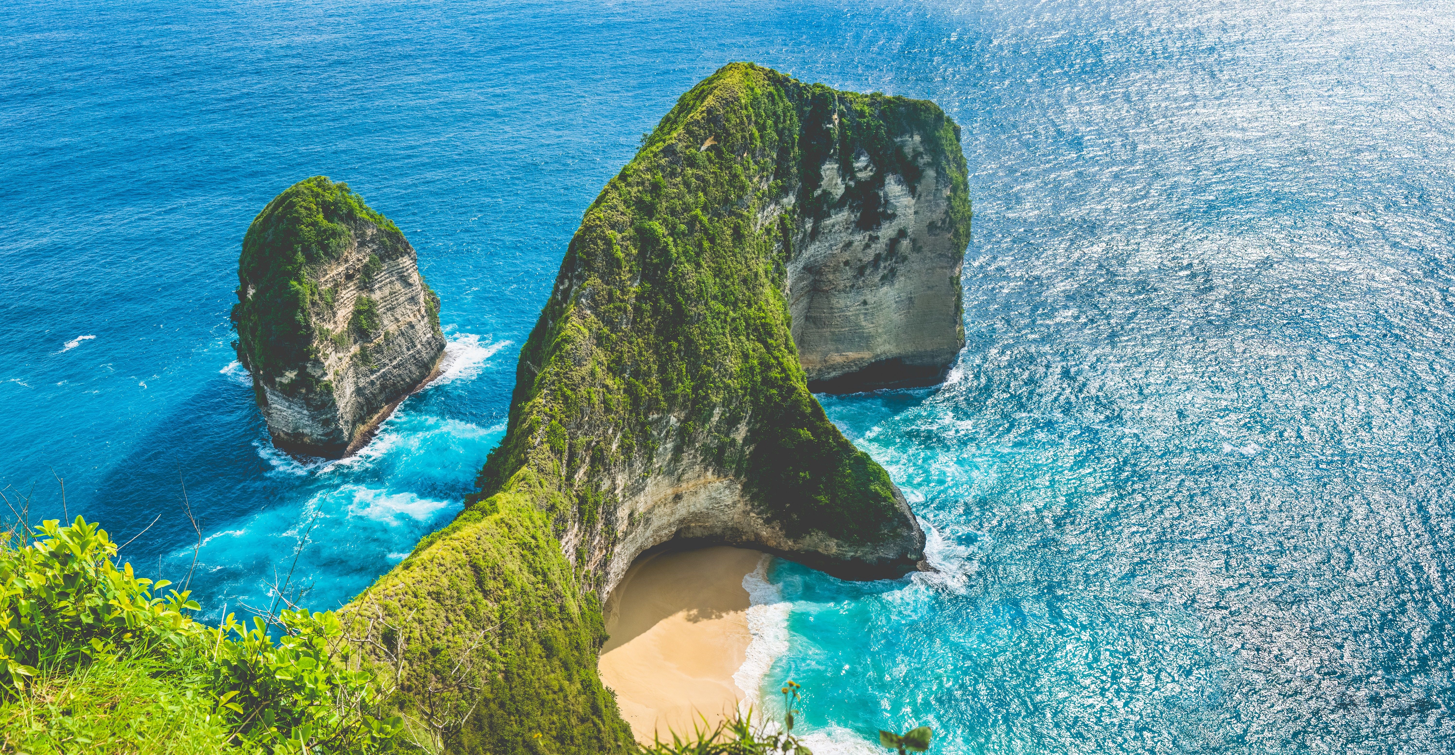 Aerial view of rock outcrop and Manta Bay into the blue seas of Nusa Penida in Bali.