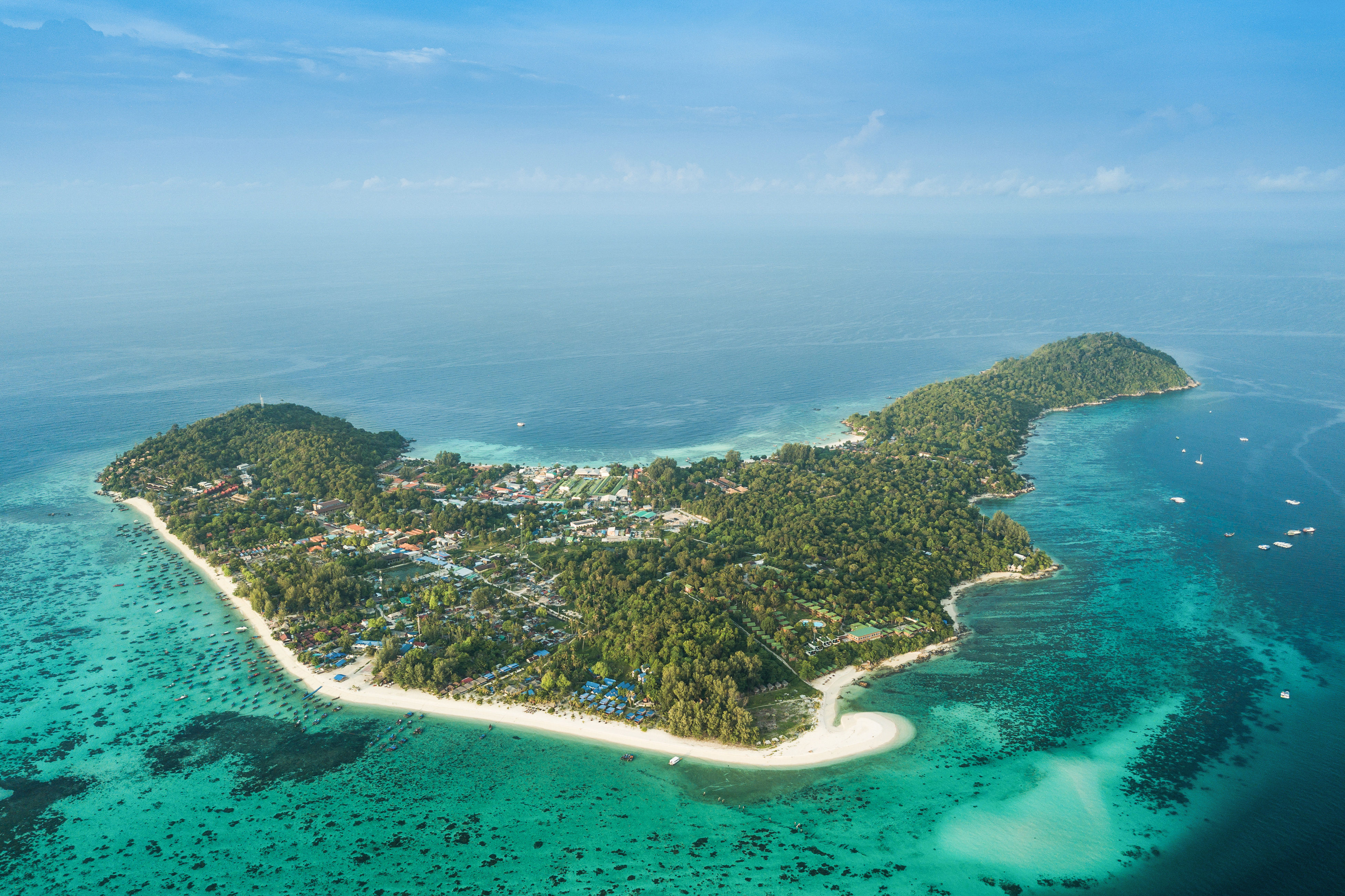 Aerial view of Koh Lipe island in Thailand fringed with white sand beaches and shallow reefs.