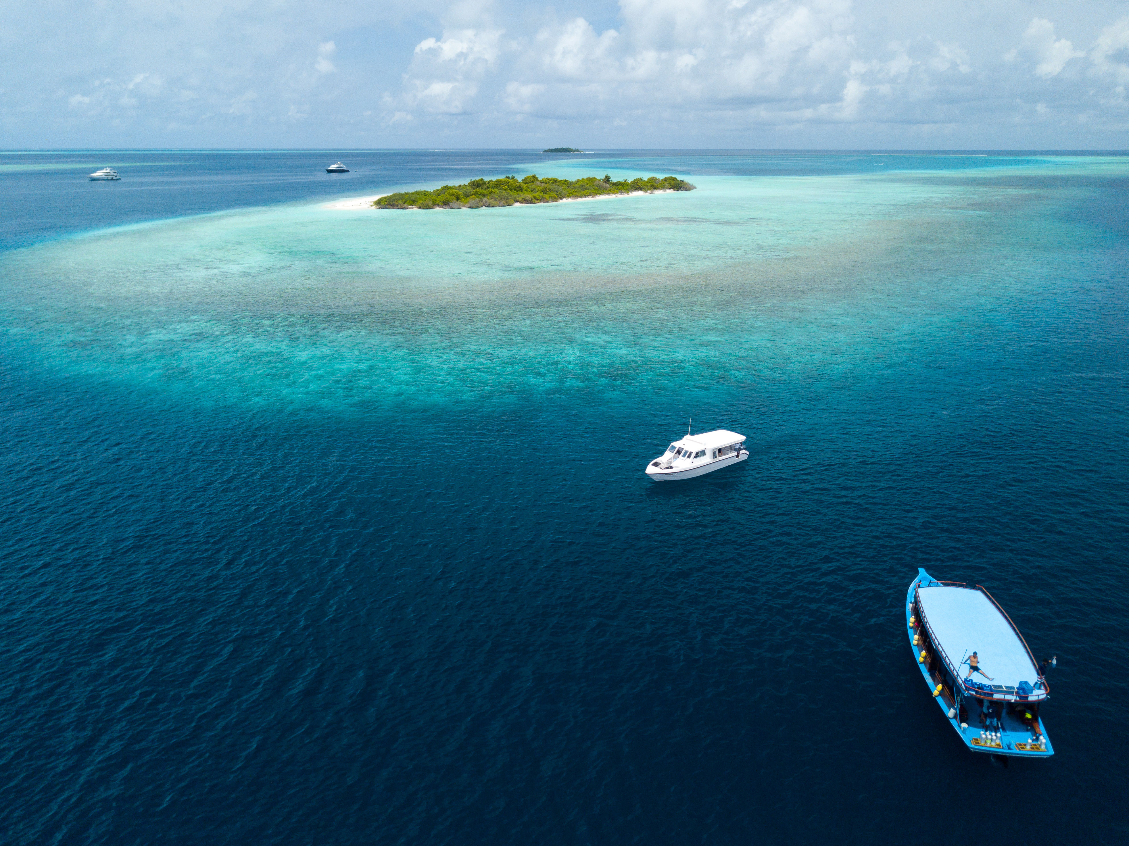 Aerial view of scuba diving boats near tropical islands in Baa Atoll Maldives.