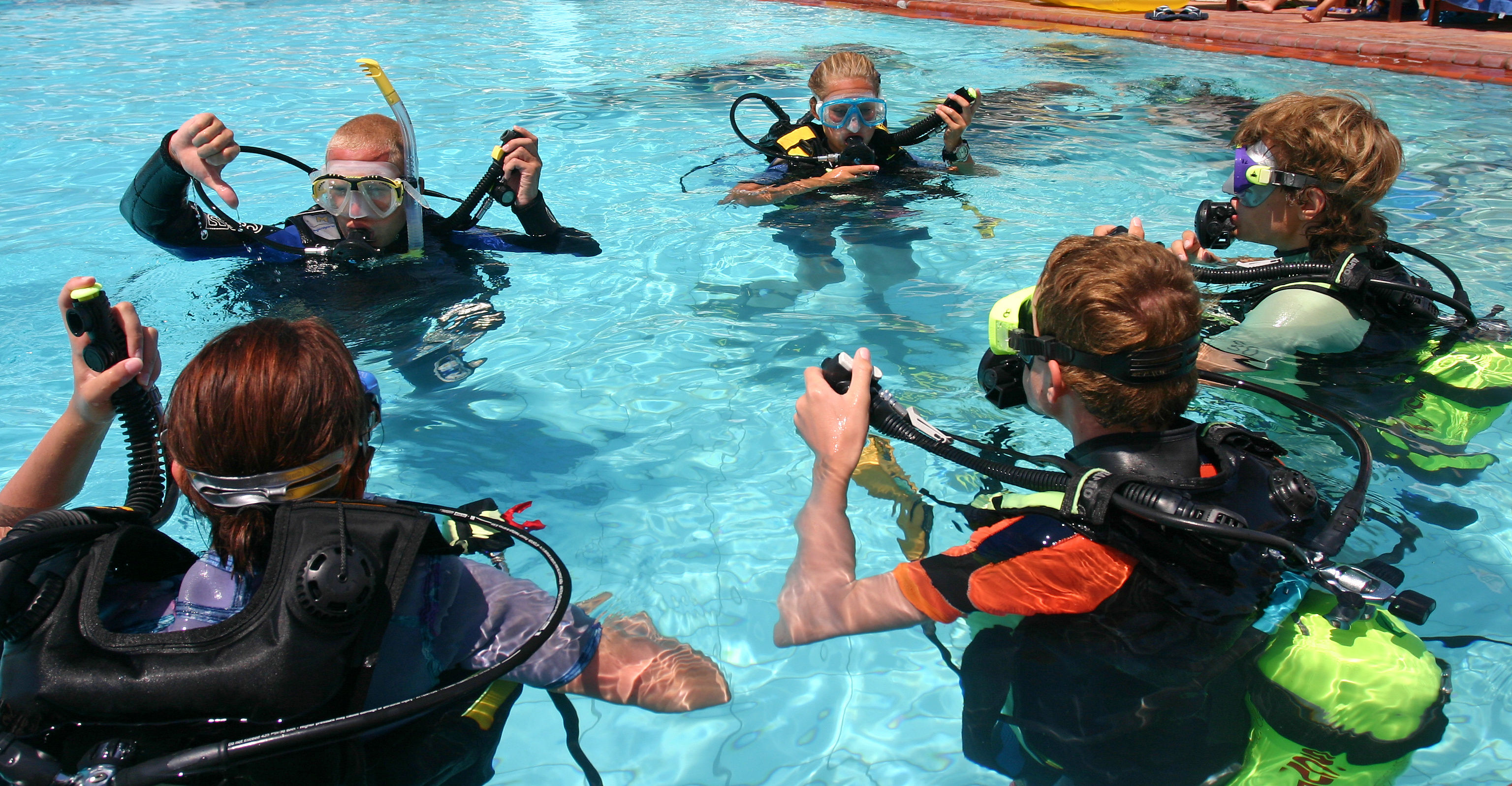 A group of scuba divers learning to dive in a swimming pool in Bangkok.