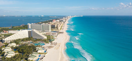 Aerial panorama view of Cancun beach strip with hotels and tropical waters. 