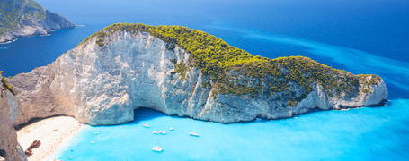 Beautiful white cliff bay with white beach and aqua blue water on a Greek island. 