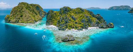 Aerial drone view of tropical Islands steep rocks and white sand beach in blue water El Nido, Mimaropa, Philippines.