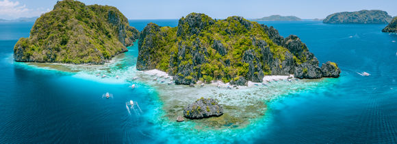 Aerial drone view of tropical Islands steep rocks and white sand beach in blue water El Nido, Mimaropa, Philippines.