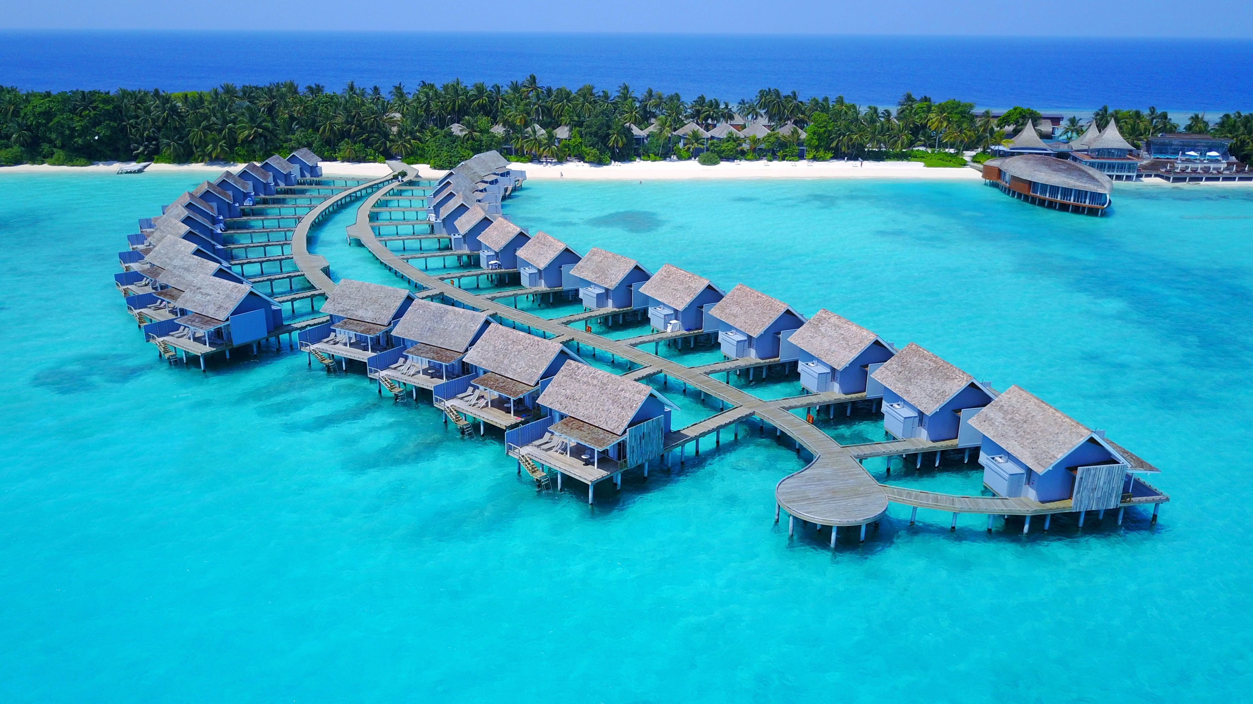 Aerial drone view of luxury water bungalow resort in the maldives. 