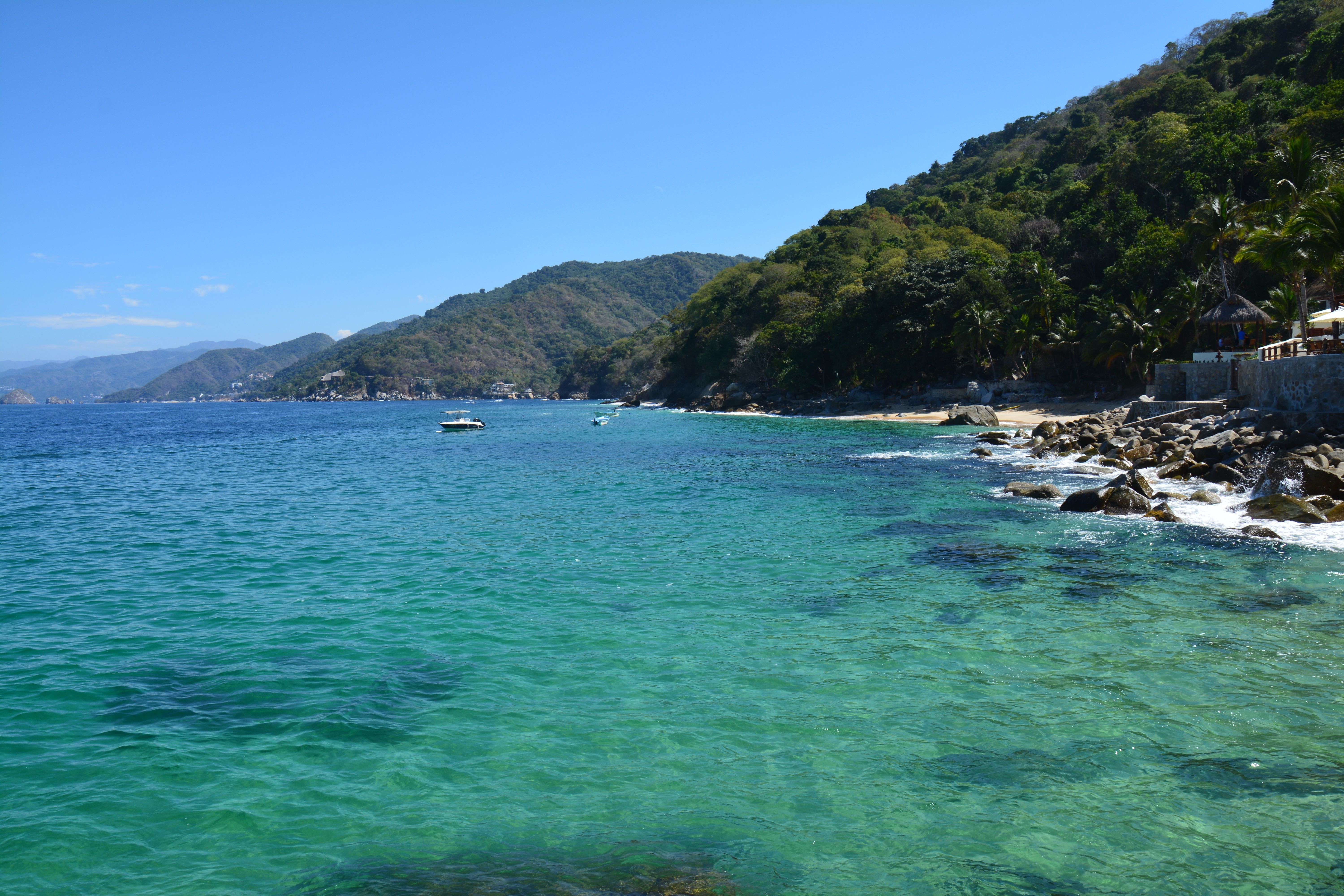 View of Mexican shore line with lush green hills and clear turquoise waters at Puerto Vallarta.