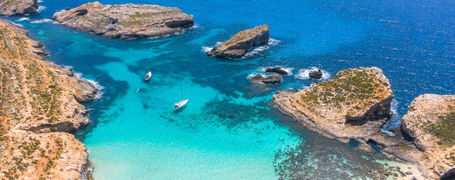 Aerial view of the clear turquoise waters and rocky outcrops of Blue Lagoon on Comino Island in Malta