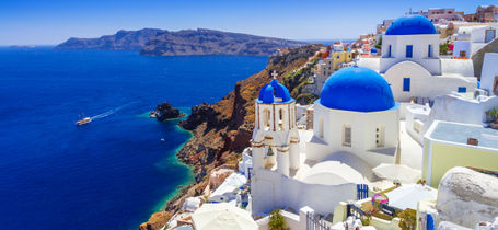 Traditional blue roofs on white building overlooking the blue seas in Santorini, Greece